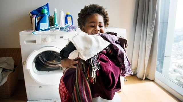 little boy doing laundry